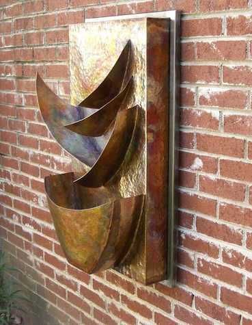 Copper water fountain mounted on a brick wall